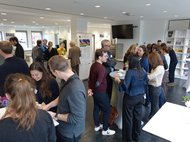 People gathered in a modern room, engaging in conversation.