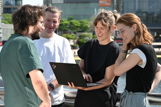 Vier Personen lächelnd im Gespräch