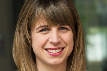 The viewer identifies a specimen of the species Homo sapiens intellectualis with straight, brown hair, wearing a dark blue striped blazer and a gold necklace with a world map pendant.