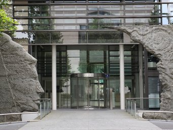 Administrative Headquarters of the Max Planck Society in Munich (© MPG/Kai Weinsziehr) Modern glass facade of the Max Planck Society building, flanked by stone sculptures.